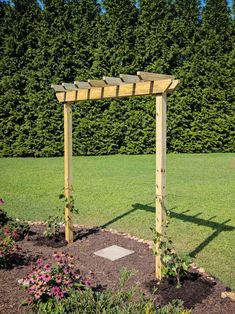 a wooden arbor in the middle of a garden