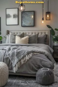 a bedroom with gray walls and pictures on the wall above the bed, along with an ottoman