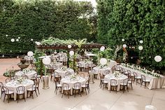 tables and chairs are set up outside for an outdoor wedding reception with white linens on them