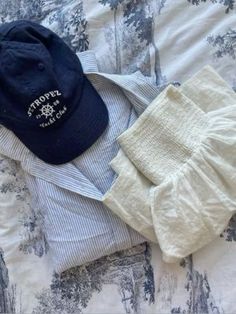 a hat, sweater and pants are laid out on a bed