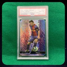 a card with a soccer player on it in a plastic case and some green background