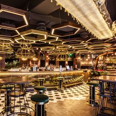 the interior of a restaurant with checkered flooring and bar stools in front of it