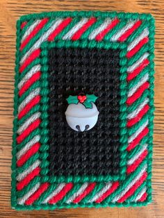 a crocheted square with a button on the center and a candy cane pattern