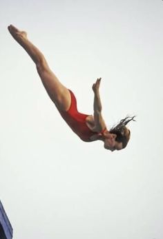 a man diving into the water from a high jump