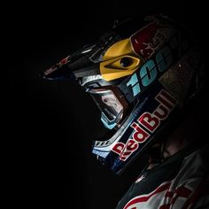 a person wearing a helmet with the word red bull on it's side and yellow eyes