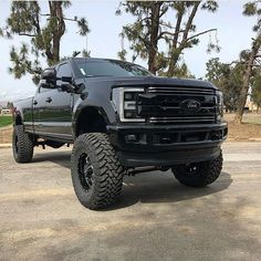 a large black truck parked on top of a parking lot