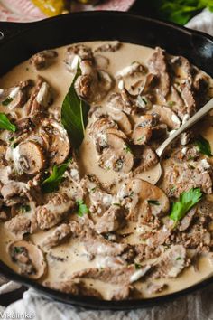 a skillet filled with mushrooms and sauce