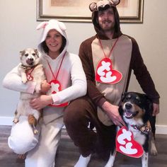 two people dressed up as dogs and one is holding a dog with hearts on it