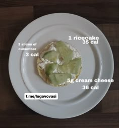 a white plate topped with a piece of bread covered in cucumber and cream cheese