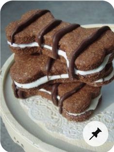 there are many cookies on the plate with chocolate drizzled on them and white icing