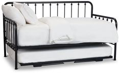 a black metal daybed with white sheets and pillows on it's side, against a white background