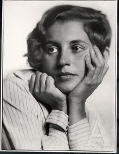 an old black and white photo of a woman holding her hand to her face with both hands