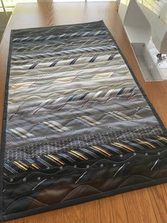 a quilted table runner on top of a wooden table