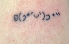 a tattoo on the back of a woman's shoulder that has arabic writing in cursive letters