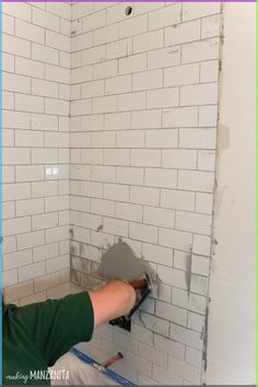 a person is working on a white brick wall