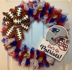 a football wreath is decorated with red, white and blue mesh