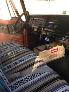 the interior of an old car with a wooden box on the seat