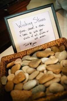 a basket filled with rocks next to a sign that says wishing stones on the table