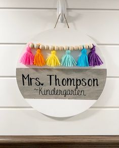 a sign that says, mrs thomas's kindergarten with tassels hanging from it