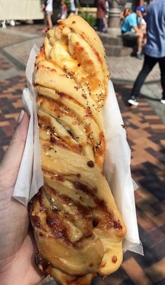 a person holding up a large pastry in their hand