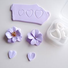 there are plastic hearts and flowers next to the molds for making heart shaped cookies