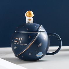 a space themed teapot with an astronaut on top