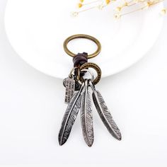 a white plate topped with a metal feather keychain