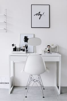 a white desk and chair in a room with pictures on the wall above it,