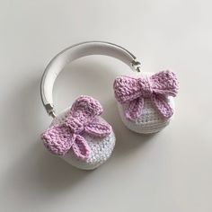 two crocheted baby shoes with bows on them