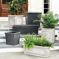 four planters sitting on the steps with plants in them