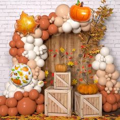 an outdoor fall scene with pumpkins, balloons and other decorations on the side of a brick wall