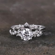 a white gold engagement ring set with a round diamond surrounded by leaves and diamonds on top