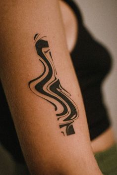 a woman's arm with a black and white tattoo design on her left arm