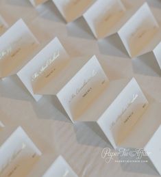 there are many place cards on top of the table cloth that is laid out in rows