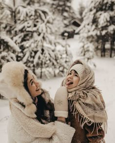 two women are laughing in the snow