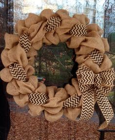 a burlocked wreath is hanging on the front door with a ribbon around it