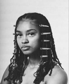 a black and white photo of a young woman with dreadlocks on her head