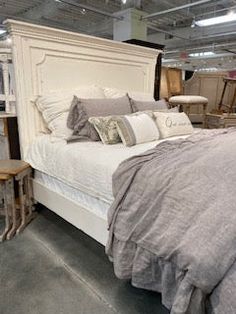 a bed sitting inside of a bedroom on top of a hard wood floor next to two tables