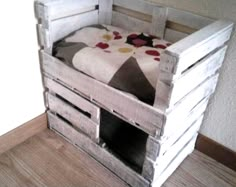 a bed made out of wooden pallets on the floor