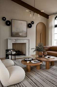 a living room with two couches and a table in front of a fire place