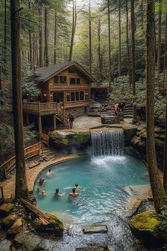 people are swimming in a pool surrounded by trees and rocks, with a cabin on the other side