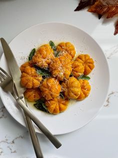 a white plate topped with dumplings covered in cheese