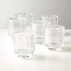 six clear glass cups sitting on top of a table