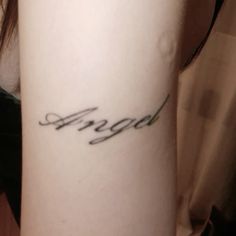 a woman's arm with the word angel written in cursive writing on it