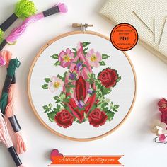 a cross stitch pattern with flowers on it next to crochet hooks and yarn