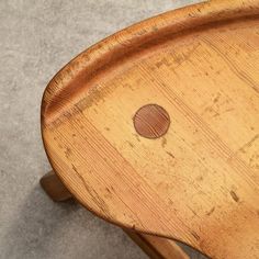 a wooden chair with a round hole in the back and seat cushion on it's side