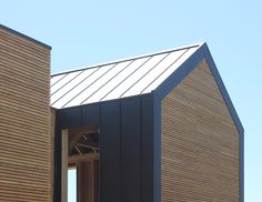 the side of a wooden building with a metal roof