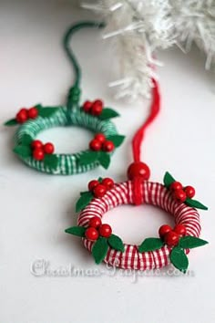 two small christmas wreaths with red berries and green leaves