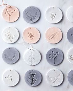 twelve handmade ceramic ornament designs on a marble surface