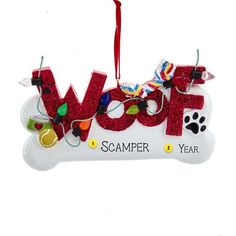 a dog bone ornament with the word woof spelled out in red glitter